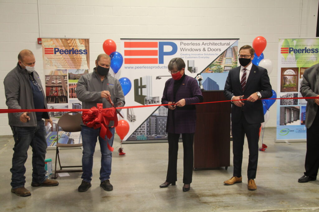 Governor Kelly, Secretary Toland and others cutting the ribbon at Peerless Products in Iola